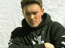 a man wearing a black hoodie with a picture of a man on it