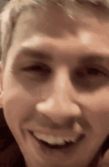 a close up of a man 's face with a smile on his face