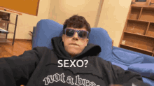 a young man wearing sunglasses and a hoodie that says not a bra
