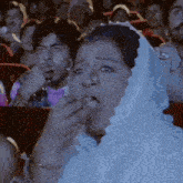 a woman in a white veil is eating a piece of food
