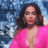 a woman in a pink dress with a plunging neckline is standing on a stage .