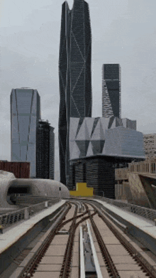 a train going through a city with tall buildings