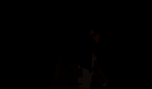 a woman in a black top is dancing in a room