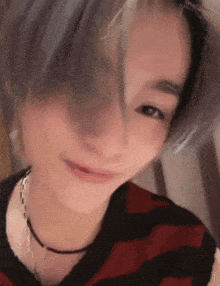 a close up of a woman 's face with a striped shirt on