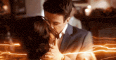 a man and a woman are kissing in a room with lightning coming out of their mouths .
