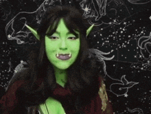 a woman with green ears and teeth is standing in front of a black background with a starry sky .