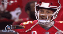 a football player wearing a helmet with a wild card nfl logo behind him