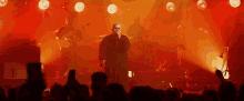 a man singing into a microphone in front of a crowd at a concert