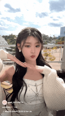 a girl with long hair is wearing a white top and a sweater