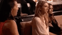 three women are sitting on a couch talking to each other . one of the women is crying .