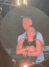 a man and a woman are hugging each other and smiling