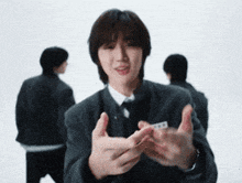 a man in a suit and tie is making a gesture with his hands
