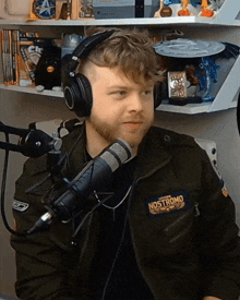 a man wearing headphones and a jacket that says " nostromo "