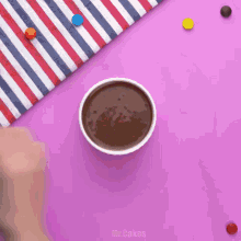 a cup of chocolate sauce is being poured into a cup