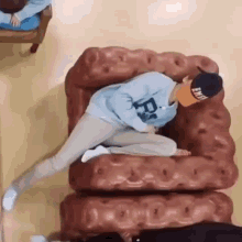 a man is laying on a couch with his legs crossed .