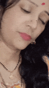 a close up of a woman wearing a necklace