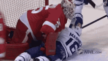 a hockey player wearing a number 16 jersey is laying on the ice