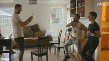 a group of men are dancing in a living room with nick written on the corner