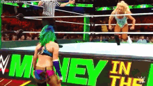 two women are wrestling in a ring with a sign that says money in the ring .