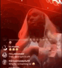 a woman is screaming in a red room while holding a cell phone .