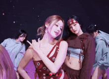 a woman in a red top with holes in it is standing next to a woman in a headband