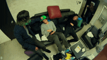 a group of people sitting on a couch with the letter d on the bottom