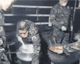 a man in a military uniform is stirring a pot of food