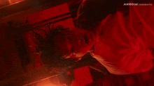 a man is laying on his back in a dark room with arrow presents written on the bottom of the image