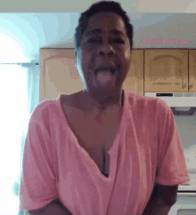 a woman in a pink shirt is standing in front of a microwave