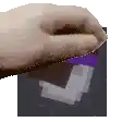 a close up of a person 's hand holding a piece of paper with a purple arrow on it .