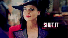 a woman wearing a hat and a red jacket with the words shut it on the bottom .
