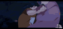 a person in a purple shirt is holding another person in their arms .