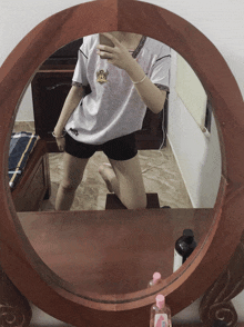 a woman taking a picture of herself in a round mirror