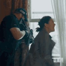 a man in a police uniform is holding a gun next to a woman in a killing eve advertisement