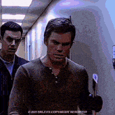 two men are walking down a hallway with a copyright reserved watermark on the bottom right