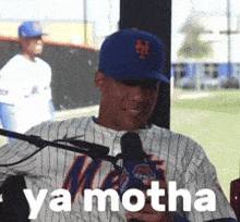 a man in a mets jersey is talking into a microphone with ya motha written on the bottom