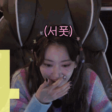 a woman sitting in a chair with a headband that says ' 서포 ' on it