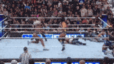 a wrestling match is going on in front of a crowd with a sign that says ' smackdown ' on it