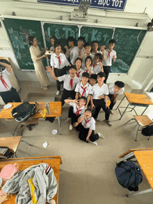 a group of students posing for a picture in front of a blackboard that says le trang ket