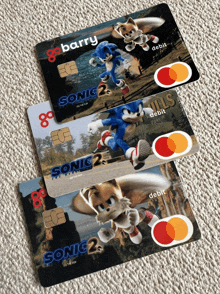 three sonic the hedgehog credit cards are on a carpet