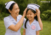 a nurse helps a little girl put on a white hat
