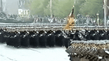 a large group of soldiers are marching down a street .