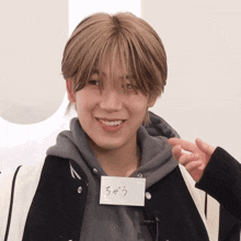 a young man with a name tag that says ' ちがう ' on it is smiling