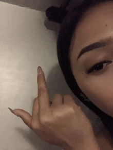a close up of a woman 's face giving the middle finger