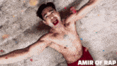a shirtless man is laying on the ground with his arms outstretched and amir of rap written on the bottom
