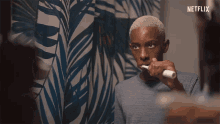 a man is brushing his teeth in front of a netflix sign