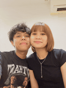 a man and a woman are posing for a picture and the man is wearing a shirt that says ' want ' on it