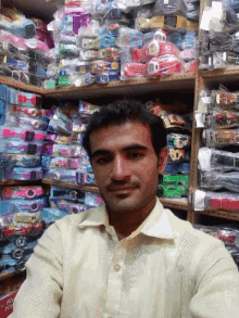 a man taking a selfie in front of a display of toys including one that says ' disney ' on it