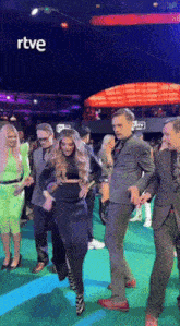 a group of people are dancing on a green carpet with rtve written on the bottom