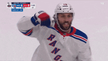 a hockey player for the new york rangers holds his fist up in the air